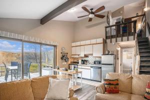 sala de estar con sofá y cocina en Quiet and Cozy Lakefront Home Near Mt Boyne, en Gaylord