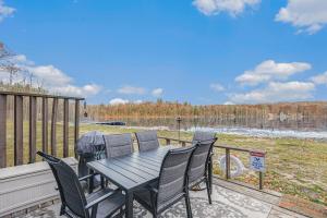 a patio with a table and chairs on a deck at Quiet and Cozy Lakefront Home Near Mt Boyne in Gaylord