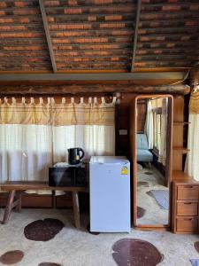 a white refrigerator in a room with a table at Pai Chao Kha in Pai