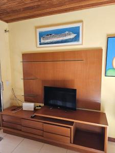 uma sala de estar com uma televisão de ecrã plano numa parede de madeira em Apartamento Buziano em Búzios
