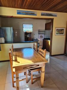 una mesa de madera y sillas en la cocina en Apartamento Buziano en Búzios