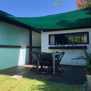 a patio with a table and chairs on a deck at Studio Centro Garopaba in Garopaba
