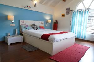 a bedroom with a large bed with a blue wall at Church Hill Cottage in Ooty