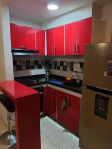 eine Küche mit roten Schränken und einer roten Theke in der Unterkunft Se Alquila Hermoso Apartamento in Neiva