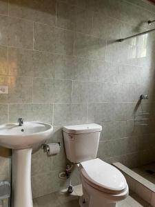 y baño con aseo y lavamanos. en Hostal Camping La Y Griega, en Bocas Town