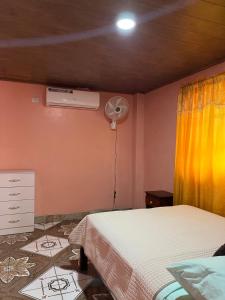 a bedroom with a bed and a air conditioner at Hostal Camping La Y Griega in Bocas Town