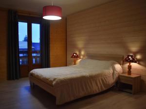 a bedroom with a bed and two lamps and a window at Chalet Font-Romeu-Odeillo-Via, 6 pièces, 12 personnes - FR-1-580-103 in Font-Romeu-Odeillo-Via