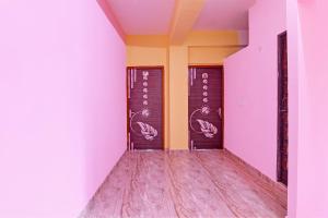 einen Korridor mit lila und gelben Wänden und Holzböden in der Unterkunft The Blue Pearl Hotel in Kalkutta
