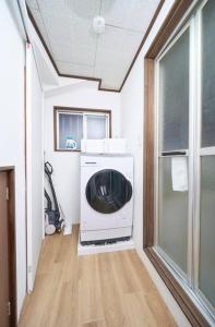 eine Waschküche mit einer Waschmaschine und einem Fenster in der Unterkunft ホテル八広 in Tokio