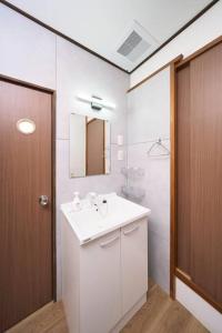 ein Badezimmer mit einem weißen Waschbecken und einem Spiegel in der Unterkunft ホテル八広 in Tokio