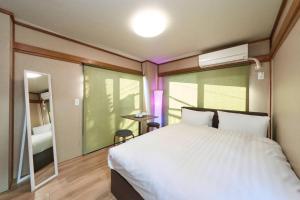 ein Schlafzimmer mit einem großen weißen Bett und einem Fenster in der Unterkunft ホテル八広 in Tokio