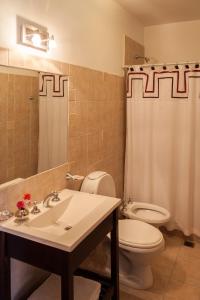 a bathroom with a sink and a toilet and a mirror at Casa del Sol Cafayate in Cafayate