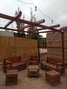 um grupo de bancos sentados sob uma estrutura de madeira em Hospedaje Puntos Cardinales em Purmamarca