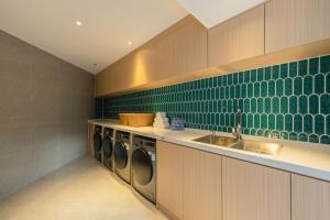 a laundry room with washing machines and a sink at The Skytel Hotel Shenzhen Central Park in Shenzhen