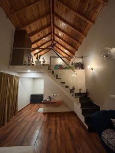 un salon avec un escalier et un canapé dans l'établissement Purna Boutique Resort - Luxury Villa with Private Pool, à Bhimtal