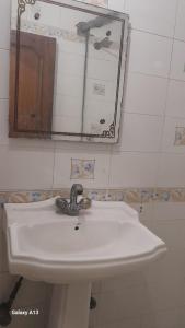 y baño con lavabo blanco y espejo. en HOTEL UDAY RAJ en Agra