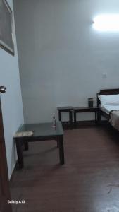 um quarto com um banco, uma cama e uma mesa em HOTEL UDAY RAJ em Agra