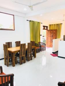a dining room with a wooden table and chairs at LSC Villa in Weligama