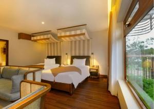 1 dormitorio con 1 cama y 1 sofá en Hoi An Ocean Front Hotel en Hoi An