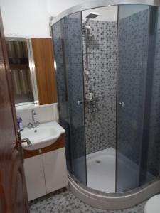 a bathroom with a shower and a sink at TOnat Caribe Hostel in West End