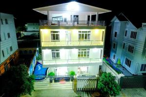 a large white building with a balcony at night at The Luxury Pool Villa Vung Tau in Vung Tau