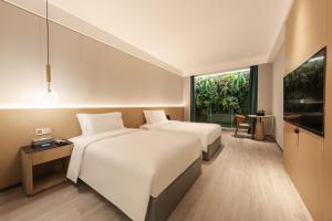 Voodi või voodid majutusasutuse The Skytel Hotel Shenzhen Central Park toas