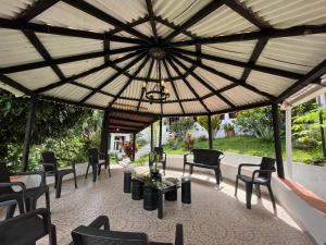 a large pavilion with chairs and tables and a chandelier at ALOJAMIENTO CAMPESTRE EN LA VEGA - A 1 HORA EXACTA DE BOGOTÁ in La Vega