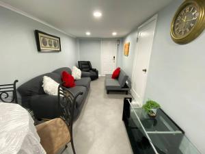 ein Wohnzimmer mit einem Sofa und einer Uhr an der Wand in der Unterkunft 1 New York City, The Best Gateway Vacations in North Bergen
