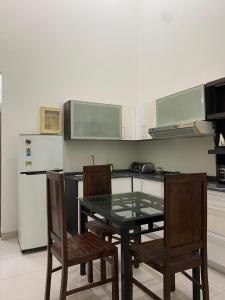 a kitchen with a table and two chairs and a refrigerator at The 8 House – Surabaya City Center in Surabaya