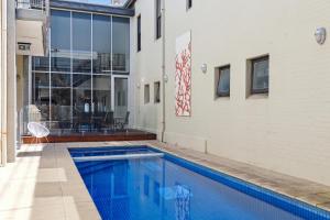 a swimming pool in front of a building at Swainson at Del Monte in Henley Beach South