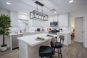 a kitchen with white cabinets and a island with chairs at Historic Roseville Retreat with Hot Tub in Roseville