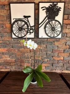 deux photos d'un vélo et d'un vase avec des fleurs dans l'établissement Rincón Natural, à Santa Rosa de Viterbo