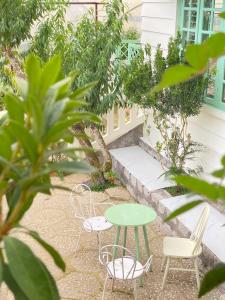 a patio with a green table and chairs at The Green Burrow - Nhà vườn mùa hè Đà Lạt in Da Thanh