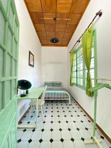 a room with a bed and a table and chairs at The Green Burrow - Nhà vườn mùa hè Đà Lạt in Da Thanh