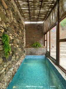 a swimming pool in a building with a stone wall at Hotel Colibri in Mineral de Pozos