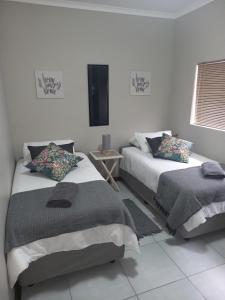 1 Schlafzimmer mit 2 Betten und einem TV an der Wand in der Unterkunft hello honey in Kimberley