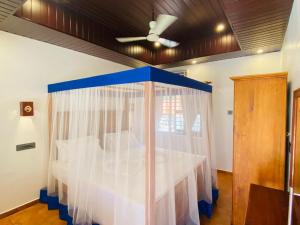 a bedroom with a bed with a blue and white canopy at Hotel Holiday Home in Kovalam