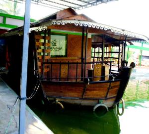THANIMA FARM LIFE في تشيتور: جلسة قارب صغير في الماء بجانب مبنى