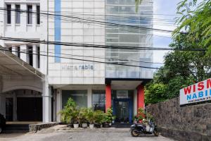 un ciclomotor estacionado frente a un edificio en Wisma Nabila near Masjid Raya Baiturrahman Banda Aceh Mitra RedDoorz, en Banda Aceh