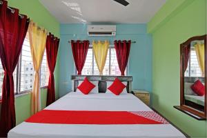 a bedroom with a bed with red and green walls at The Blue Pearl Hotel in Kolkata