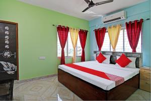 a bedroom with a bed with red and yellow curtains at The Blue Pearl Hotel in Kolkata