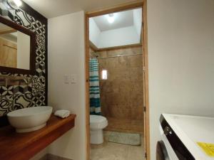 uma casa de banho com um chuveiro, um WC e um lavatório. em El Cedro y su comodidad em Loreto