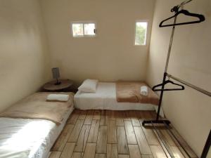 1 dormitorio con 2 camas y suelo de madera en El Cedro y su comodidad en Loreto