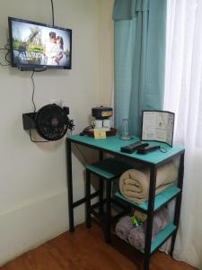 escritorio en una habitación con TV en la pared en Hotel Cotobruseño, 