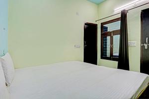 Garhi HarsāruにあるOYO D Ekant Hotelのベッドルーム(白いベッド1台、窓付)
