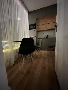 a kitchen with a table and two chairs in a room at Cozy house in the forest in Borjomi