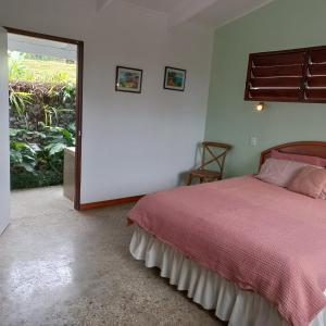 a bedroom with a bed and a large window at Stay at Eden on the River in Port Vila