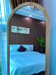 a bed in a room with a wooden headboard at Lightning Riverside in Hanoi