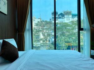 a bed in a room with a large window at Lightning Riverside in Hanoi