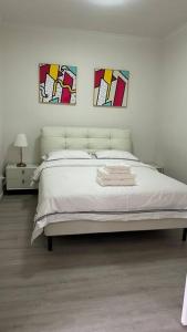 a bedroom with a bed with two pictures on the wall at Centro Gungahlin in Harrison